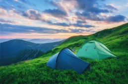Dwa namioty rozłożone na trawiastej polanie